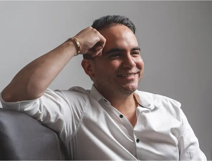 Jack Rojas, corredor inmobiliario con licencia en Florida, sonríe con camisa blanca en Miami para Domus Real Estate.